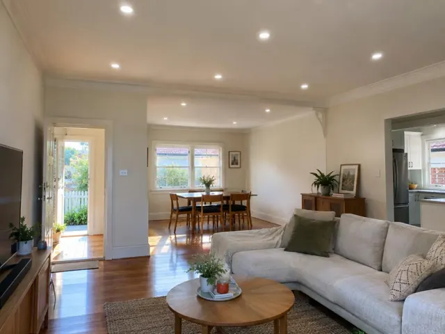 Living room with recessed ceiling downlights, timber floors and dining area in Ryde